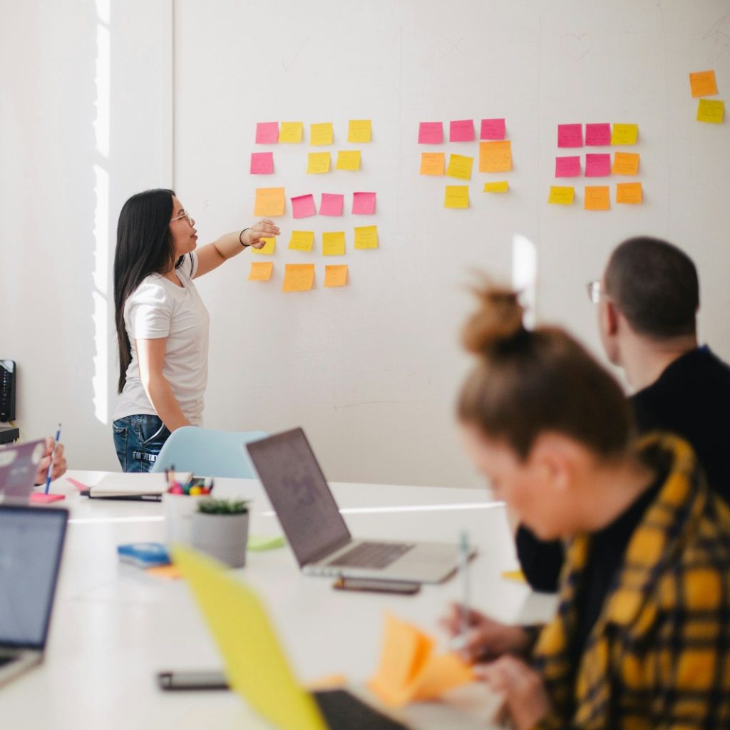 Photo by Jason Goodman woman placing sticky notes on wall